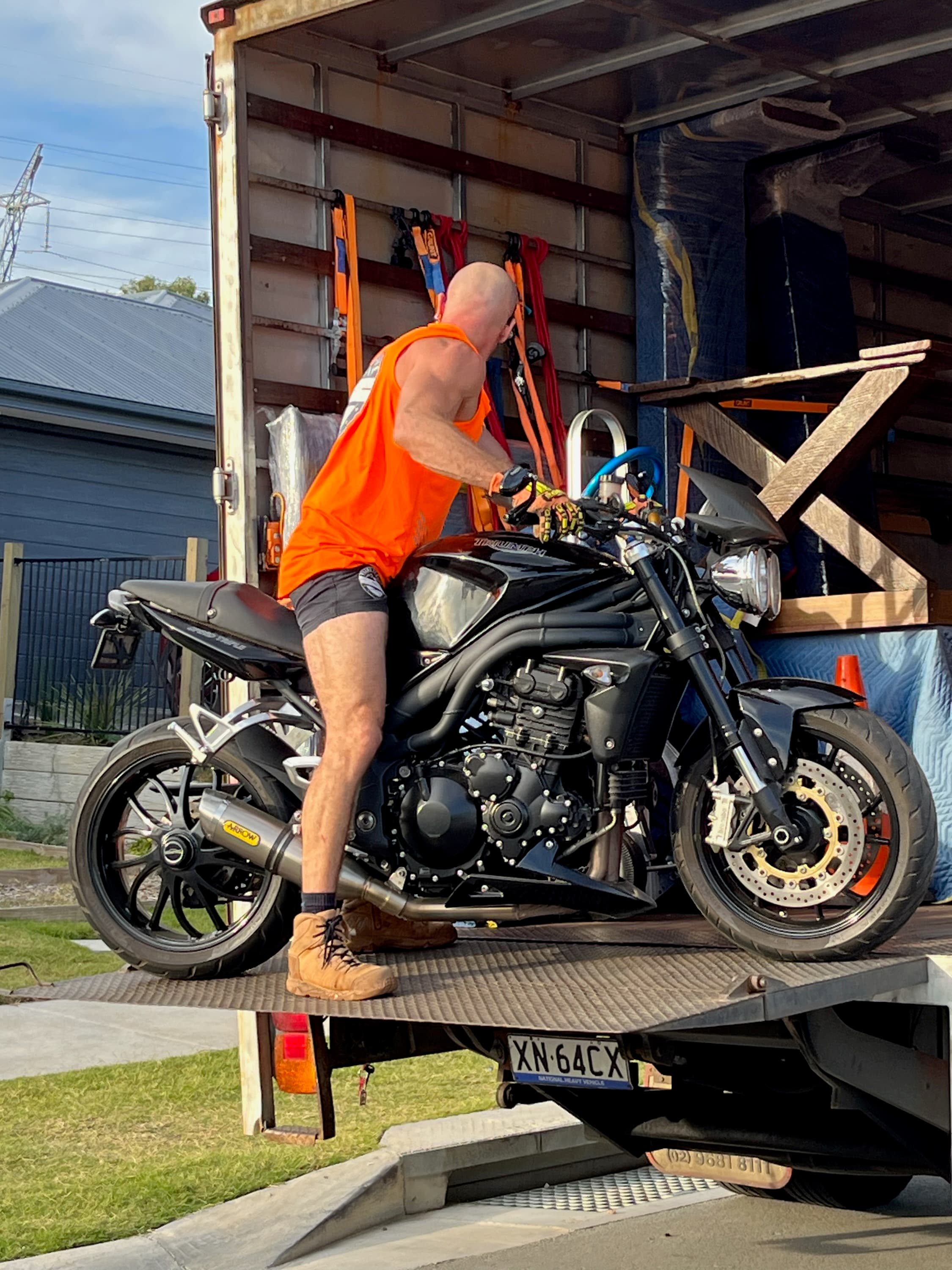 Ready To Move loading a motorbike onto the truck tail-lift for a backloading run